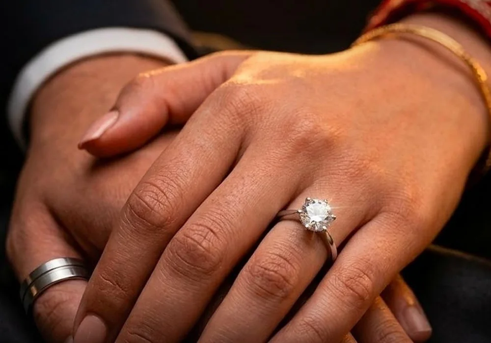 A couple's hands wearing the His & Hers rings